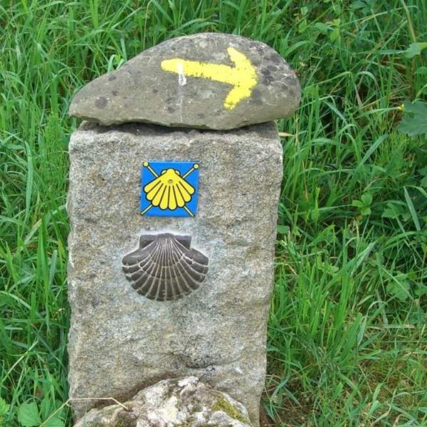 Wegmarkierungsstein mit erhabener Jakobsmuschel